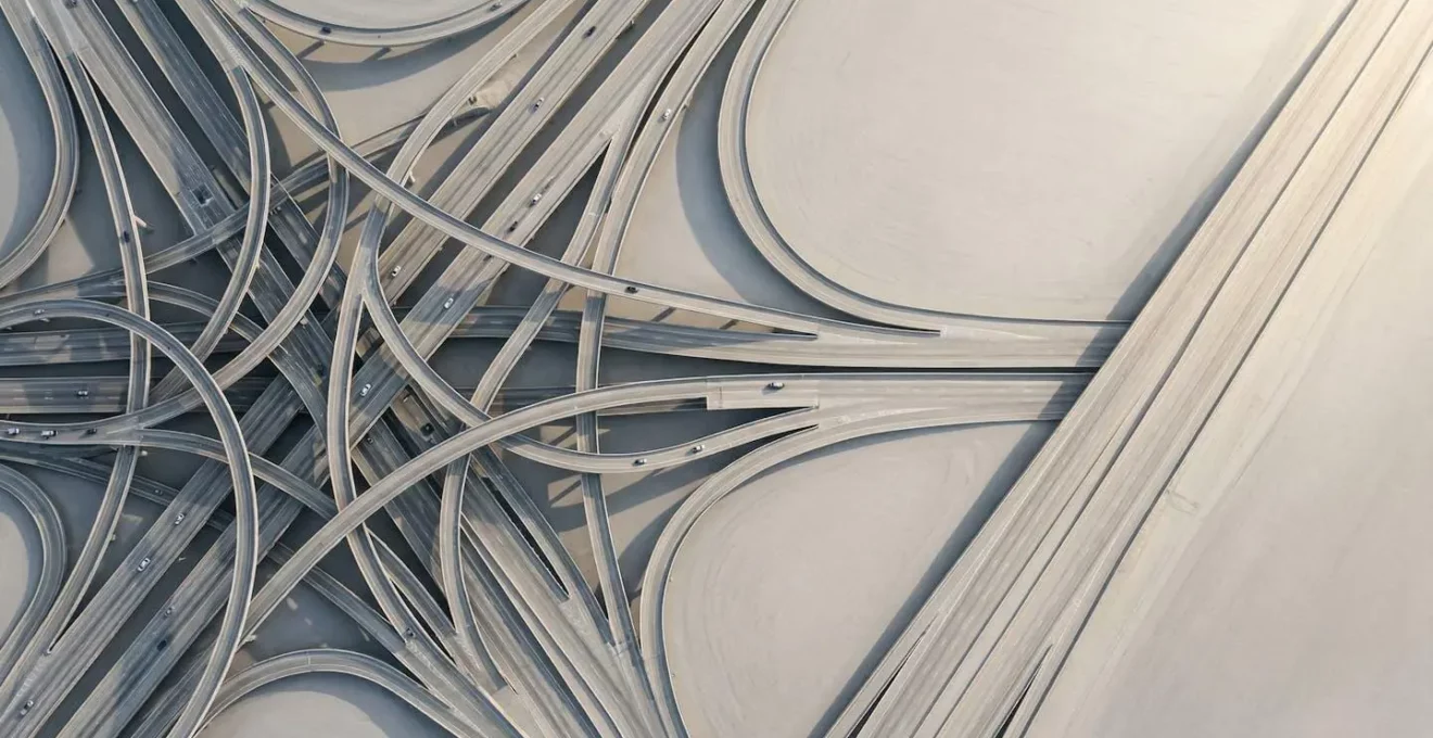 Vue aérienne d'un carrefour complexe avec plusieurs chemins qui convergent vers une seule route directe et fluide