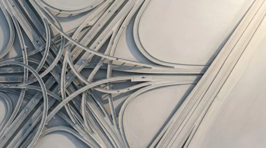 Vue aérienne d'un carrefour complexe avec plusieurs chemins qui convergent vers une seule route directe et fluide